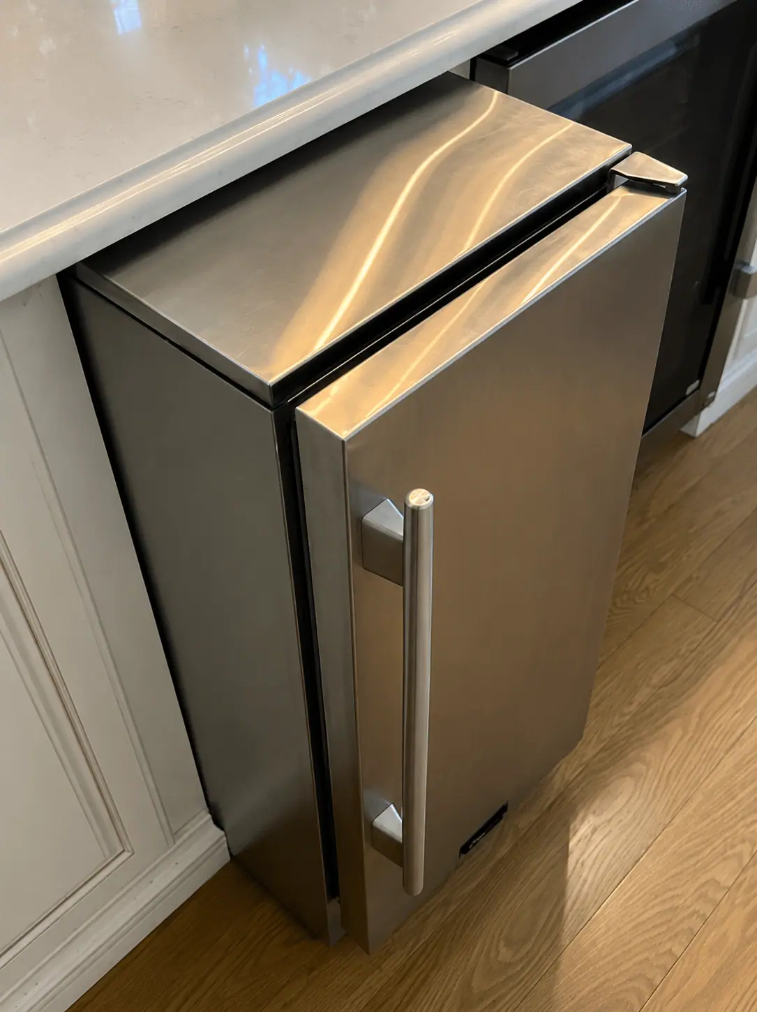 Stainless undercounter ice maker in a kitchen