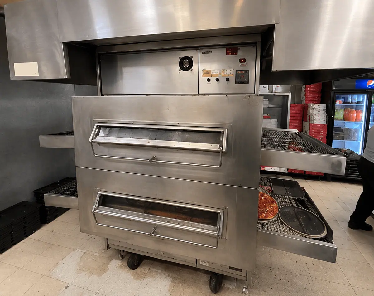 Commercial conveyor pizza oven in a restaurant kitchen