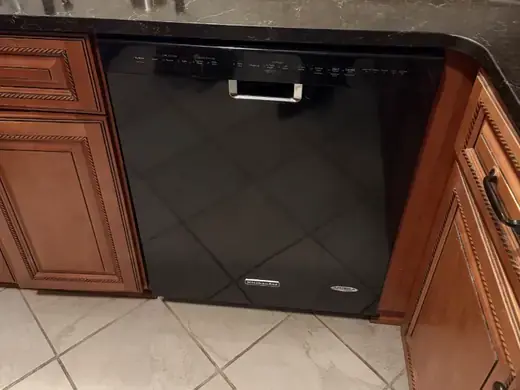 KitchenAid dishwasher under a granite countertop