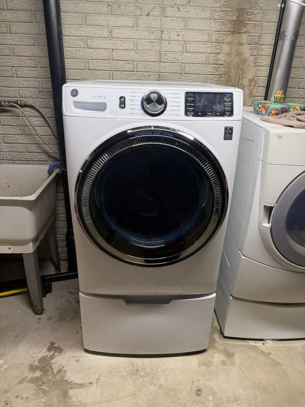 Front-load washer on a pedestal in a laundry room